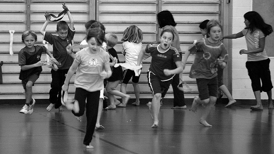 Kinder rennen in einer Sporthalle