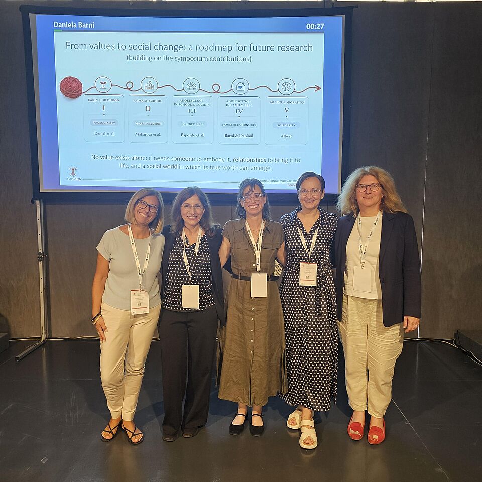 Gruppenfoto mit Elena Makarova vor einer Präsentationsfolie von Daniela Barni