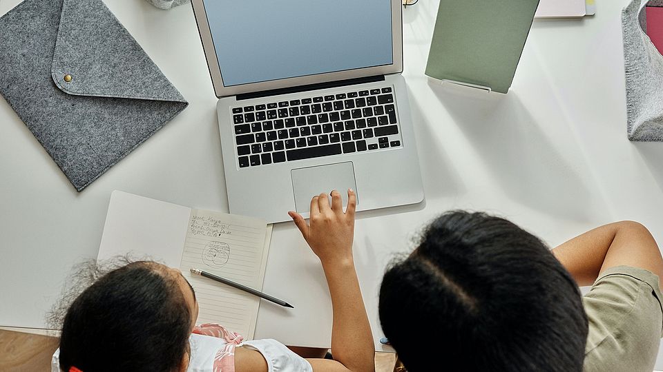 Mädchen und Frau vor einem Computer