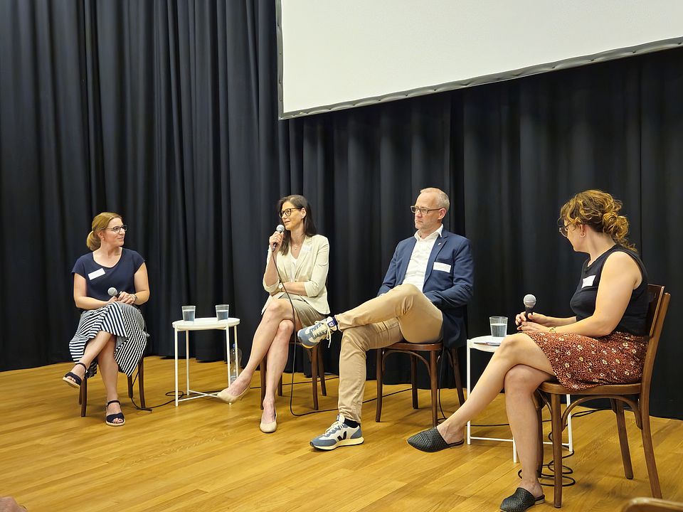 Vier Personen sitzen in einer Podiumsrunde