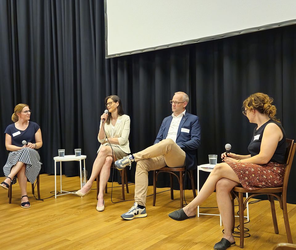 Vier Personen sitzen in einer Podiumsrunde