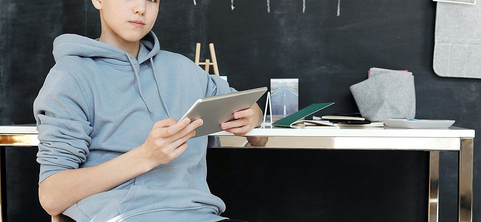 Junge mit Ipad in einem Klassenzimmer