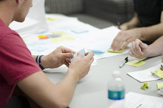 Personen an einem Tisch mit Post-its