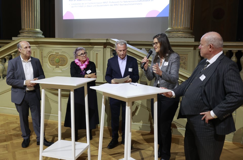 die 5 TN an der Paneldiskussion stehend an zwei Tischen in der Semperaula der ETH Zürich